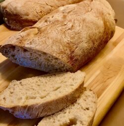 Selbstgemachtes Chiabatta-Brot mit Dinkelmehl auf einem Holzbrett angerichtet.