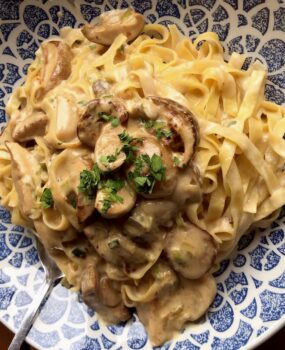 Linguini mit frischen Steinpilzen in einer Sahne-Sauce mit Petersilie garniert.