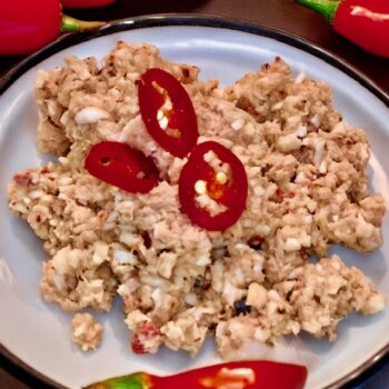 Mashuni-Roshi-Tunfisch-Kokos-Salat mit roten Chili auf einem Teller angerichtet.