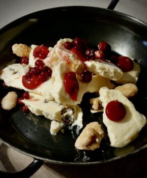 Geeister Kaiserschmarrn mit roten Früchten auf einem Teller angerichtet.