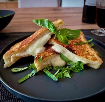 Mozzarella in Carrozza aufgeschnitten mit Basilikum garniert.