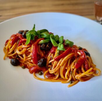 Pasta Peperonata - Spaghetti mit Paprikagemüse auf einem hellem Teller angerichtet