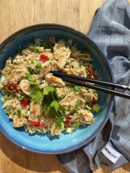 Gebratener Eierreis mit Hühnchen in einer Schüssel dekorativ serviert.