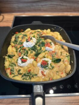 Gnocchi mit Tomaten-Spinat-Sauce und Burrata-Flecken in der Harecker Pfanne zubereitet