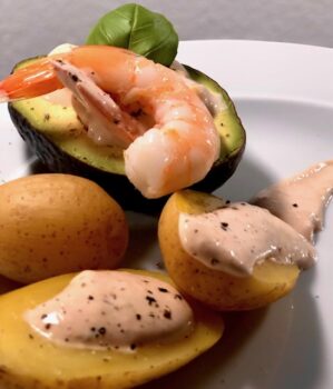 Teller mit Ofenkartoffeln, Shrimps und Avocado, ein leckeres Gericht, das sich für jede Gelegenheit eignet.