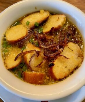 Aufgeschmolzene bayerische Breznsuppe in einem Suppenteller angerichtet und mit Schnittlauch garniert.