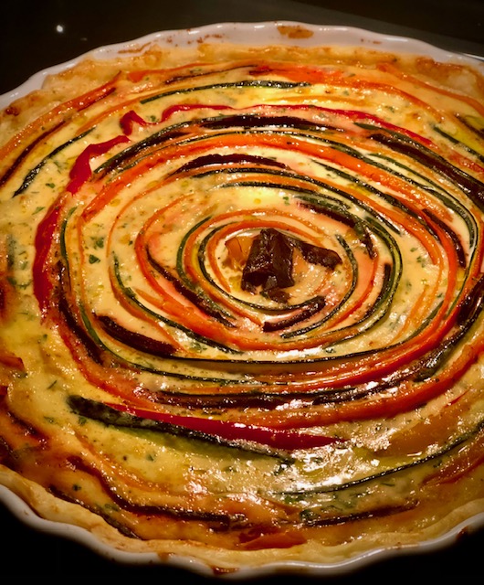 Eine Gemüse Quiche mit vielen Farben in der Form duftend warm und frisch aus dem Ofen