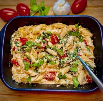 Pasta mit Feta, Spinat und Cocktailtomaten aus dem Ofen in der Auflaufform serviert.