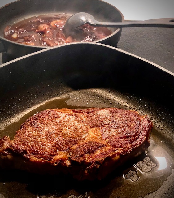 Ein duftendes Steak und karamellisierte Balsamico Zwiebeln in einer Pfanne.