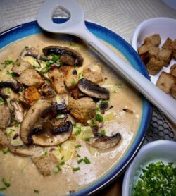 Brotsuppe mit Champignons in einer dekorativen Schüssel zum Servieren.