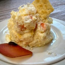 Spanischer Kartoffelsalat mit Thunfisch, Erbsen und Möhren auf eine Teller angerichtet.