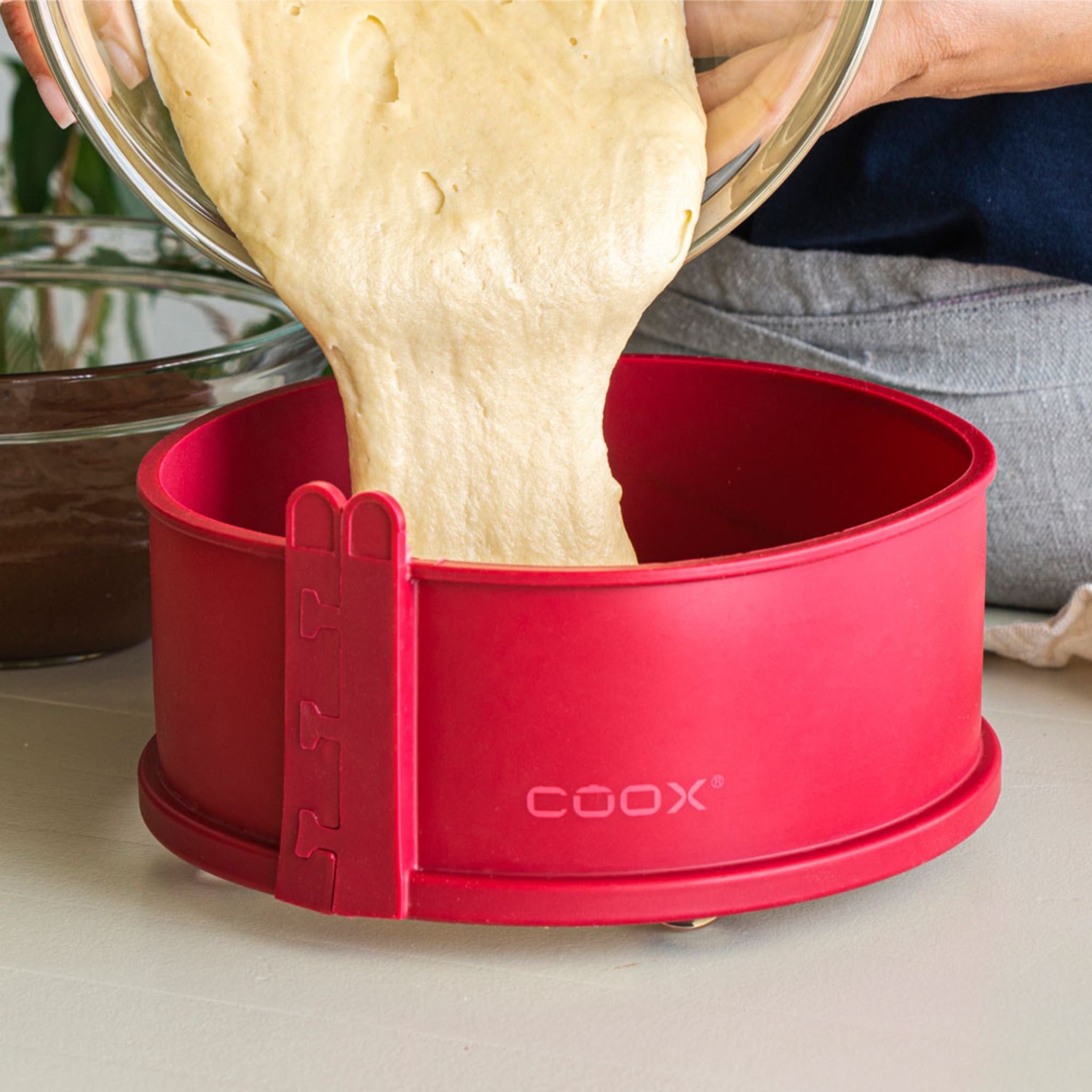 Rote Coox Springform 26 cm aus Silikon mit Teigfüllung und Metallverschluss.