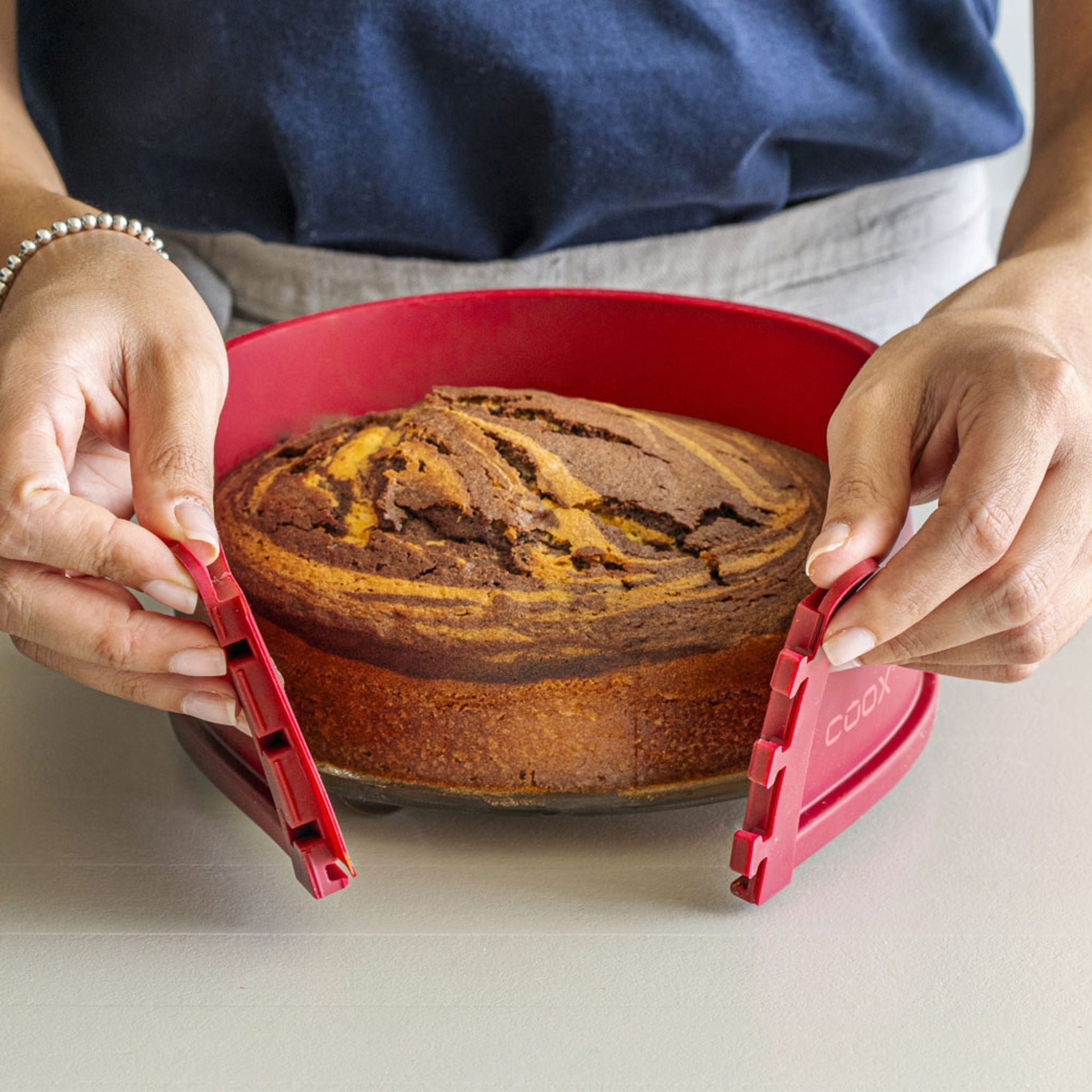 Backform aus rotem Silikon mit Marmorkuchen, 26 cm, mit abnehmbarem Boden.